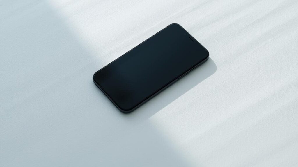 余白の多い明るい空間に置かれたスマホ。返信を待つ時間の静けさから、マッチングアプリで2回目に会う基準を判断する際の心境。